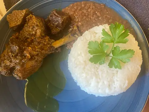 Cari mijoté au feu de bois, servi avec du riz