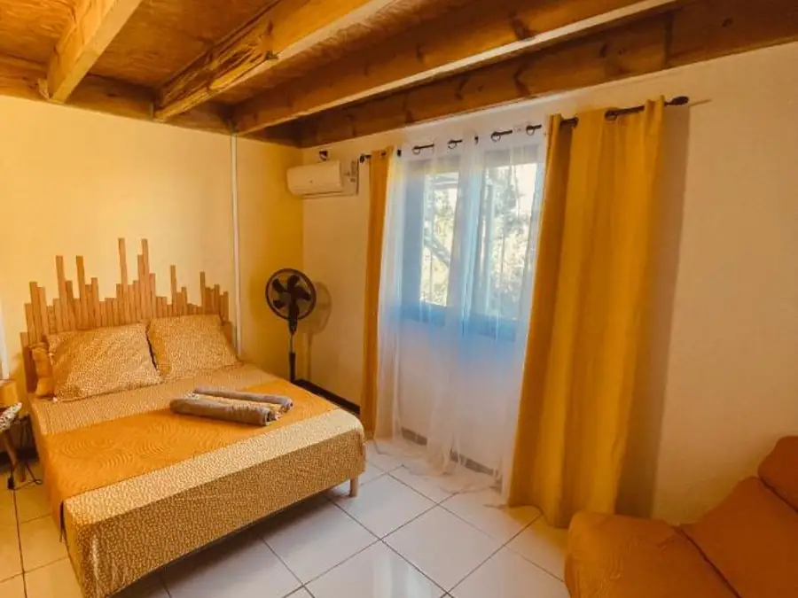 Le lit double sous le plafond en bois
