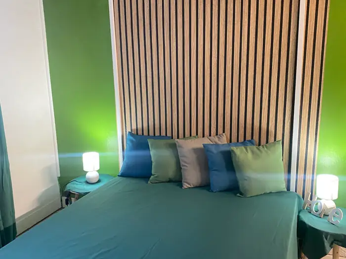 Chambre verte avec lampes de chevet allumées