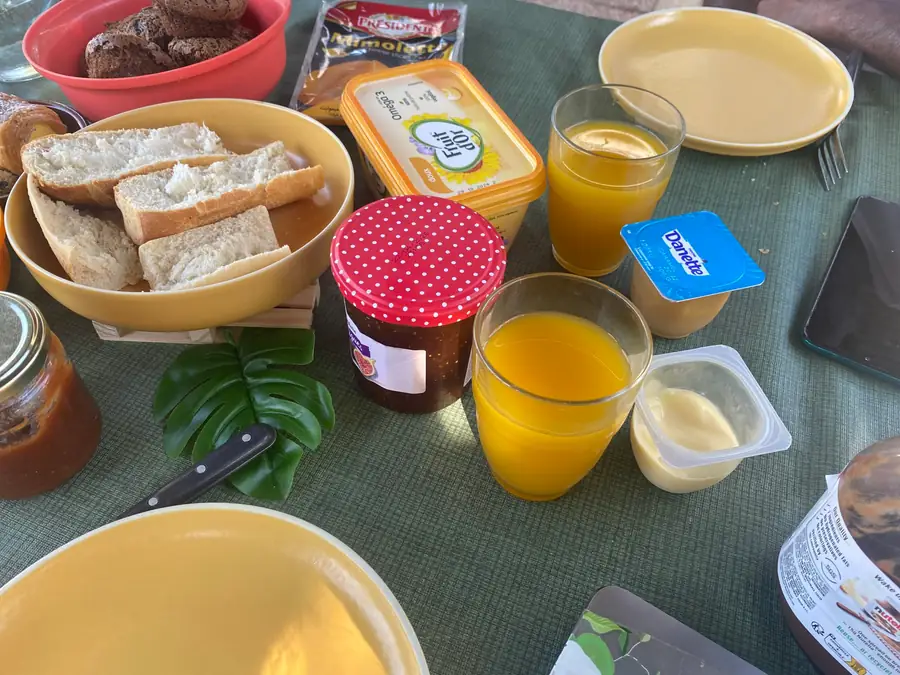 Petit-déjeuner servi en extérieur : viennoiseries, jus et fruits